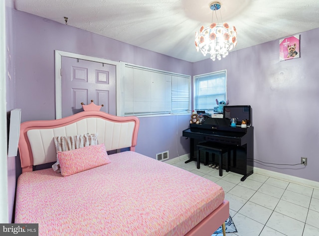 tiled bedroom featuring a textured ceiling and an inviting chandelier