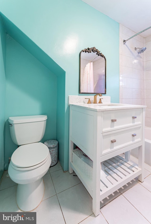 bathroom featuring tile patterned floors, toilet, vanity, and tiled shower