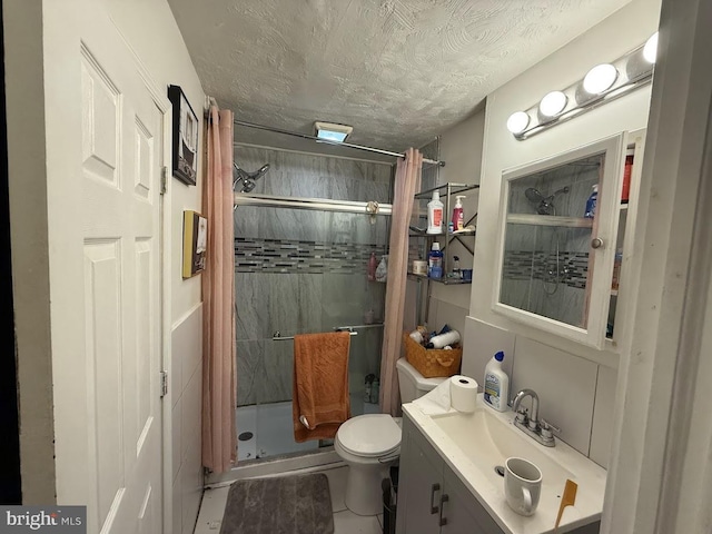 bathroom featuring vanity, a shower with curtain, toilet, and a textured ceiling