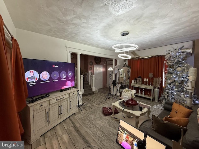 living room with ornate columns and a textured ceiling