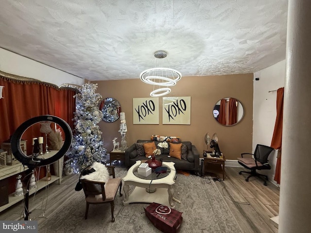 living room with a textured ceiling, a chandelier, and hardwood / wood-style flooring