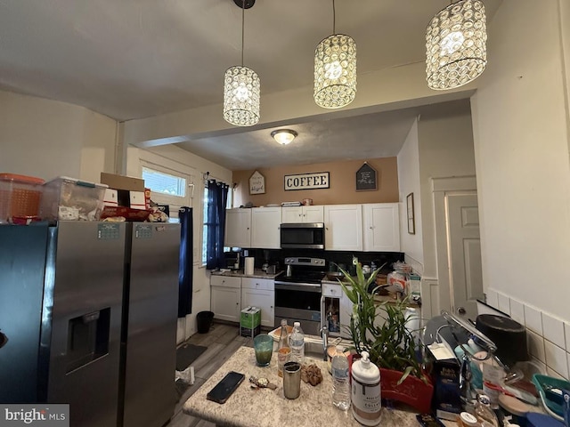 kitchen with white cabinetry, appliances with stainless steel finishes, dark wood-type flooring, and pendant lighting