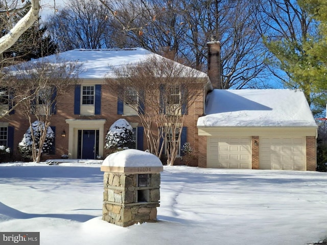 colonial home featuring a garage and brick siding