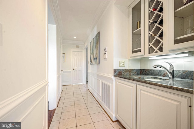 interior space featuring light tile patterned floors, crown molding, and sink