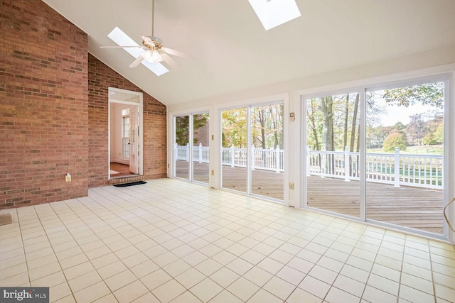 unfurnished sunroom with ceiling fan and vaulted ceiling with skylight