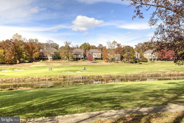 surrounding community with a yard and a water view