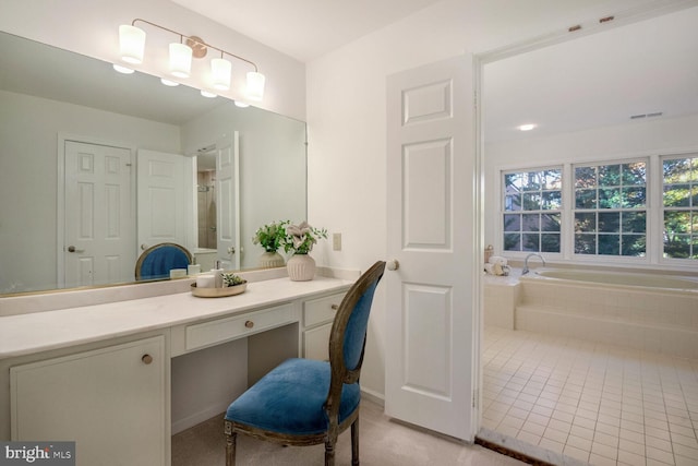 bathroom featuring tiled bath, tile patterned flooring, and vanity