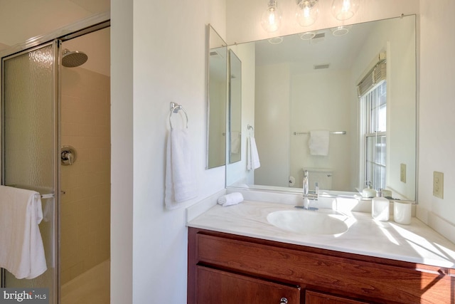 bathroom with toilet, a shower with door, and vanity