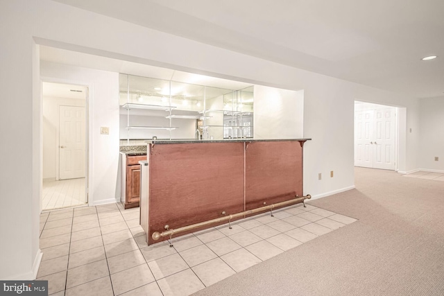 kitchen featuring dark stone counters and light colored carpet