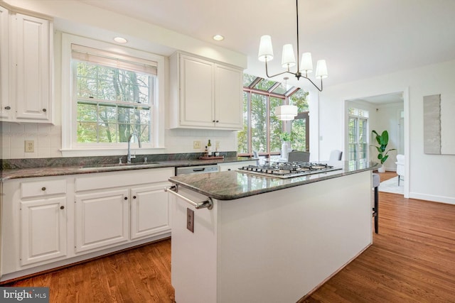 kitchen with sink, a kitchen island, and white cabinetry