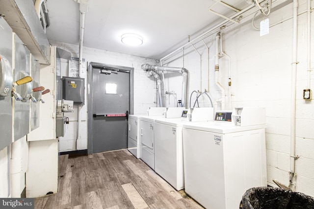 clothes washing area featuring hardwood / wood-style flooring and washer and clothes dryer