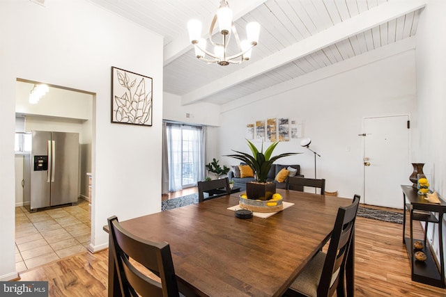 dining room with light wood-type flooring, a chandelier, and beamed ceiling