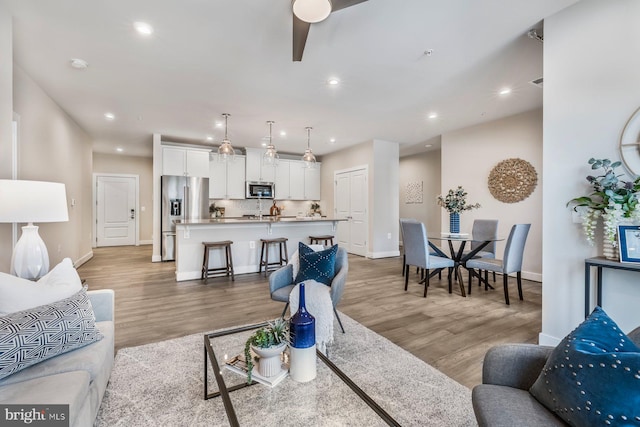 living room featuring ceiling fan and hardwood / wood-style flooring