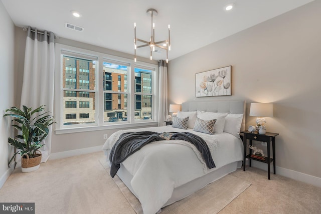 bedroom featuring light carpet and a chandelier