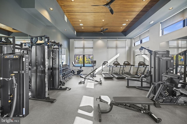 exercise room with a high ceiling, a wealth of natural light, ceiling fan, and wooden ceiling