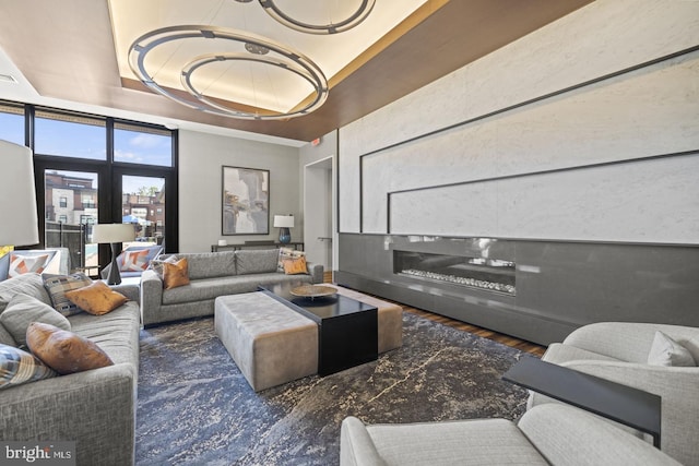 living room featuring a raised ceiling and dark hardwood / wood-style floors