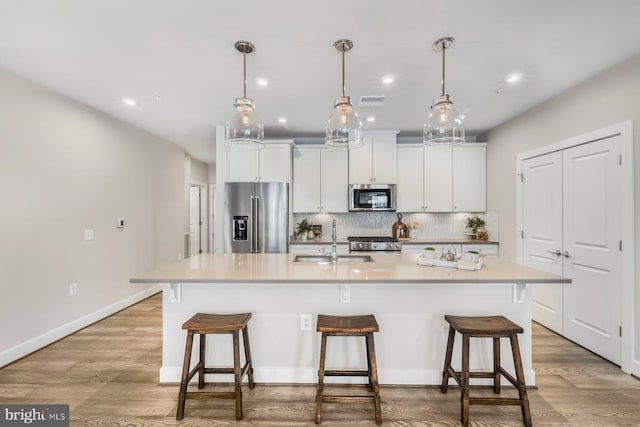 kitchen featuring stainless steel appliances, a large island, white cabinets, and sink