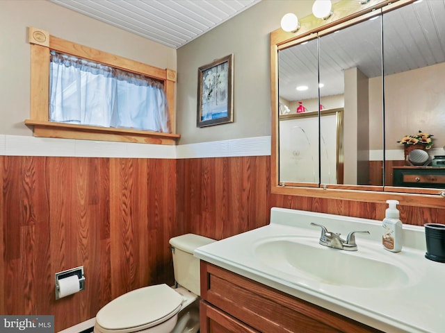 bathroom featuring wooden walls, vanity, and toilet