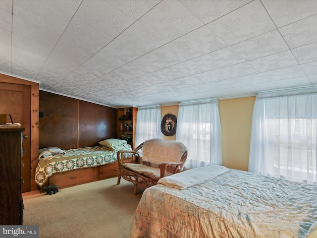 bedroom with carpet floors and wooden walls