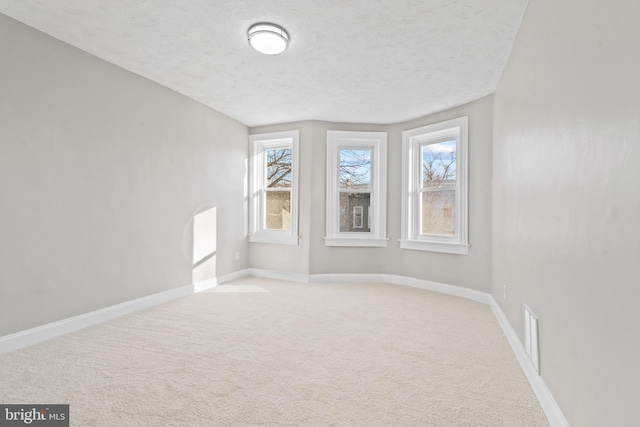 carpeted spare room featuring a textured ceiling