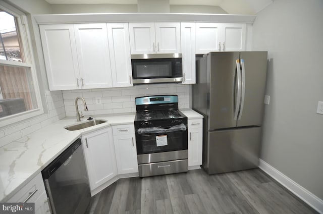 kitchen with appliances with stainless steel finishes, decorative backsplash, and white cabinetry