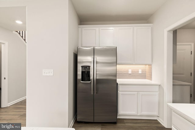 kitchen with stainless steel fridge with ice dispenser, dark hardwood / wood-style floors, tasteful backsplash, and white cabinetry