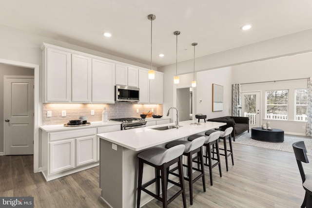 kitchen with appliances with stainless steel finishes, white cabinetry, and sink