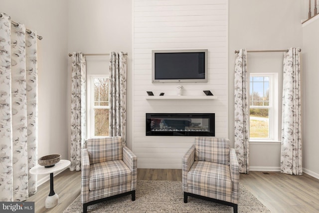 sitting room featuring a fireplace and wood-type flooring