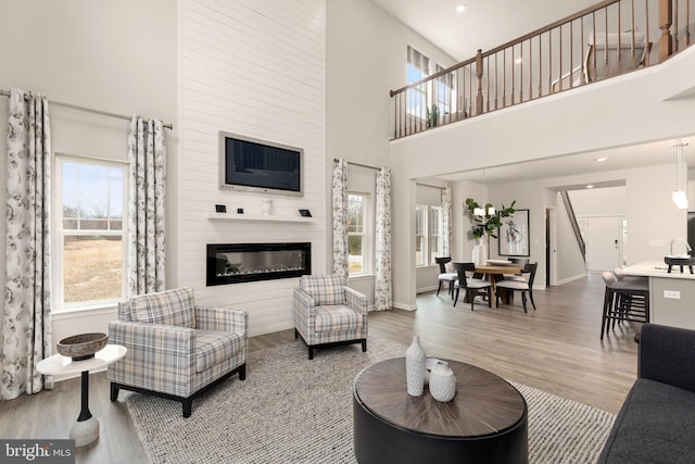 living room featuring a high ceiling, a large fireplace, and a healthy amount of sunlight