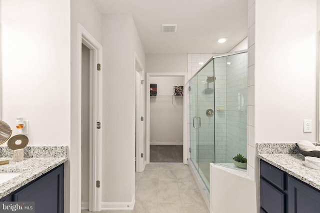 bathroom with tile patterned flooring, a shower with shower door, and vanity