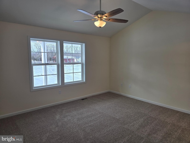 carpeted spare room with ceiling fan and vaulted ceiling