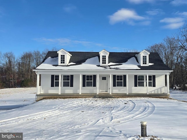 cape cod home featuring covered porch