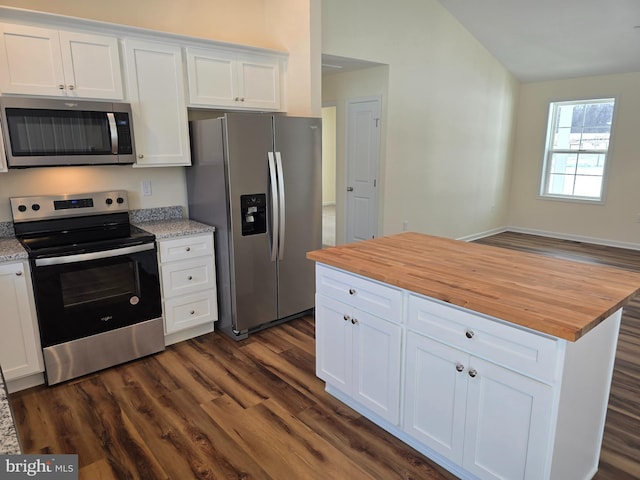 kitchen featuring white cabinetry, wooden counters, stainless steel appliances, dark hardwood / wood-style floors, and vaulted ceiling