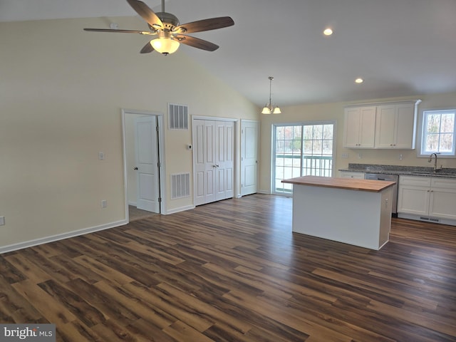 kitchen with butcher block countertops, dark hardwood / wood-style floors, white cabinetry, and pendant lighting