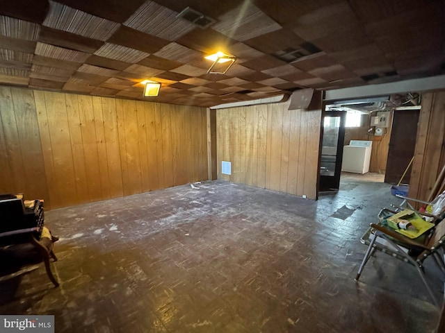 basement with washer / dryer and wooden walls