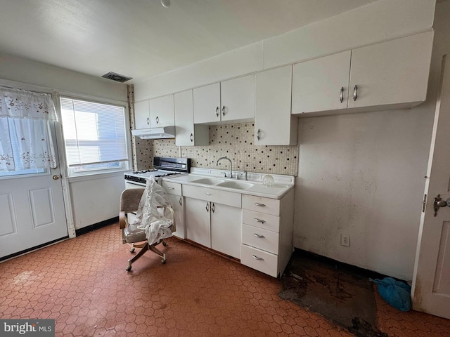 kitchen featuring sink, white cabinets, decorative backsplash, and white gas range