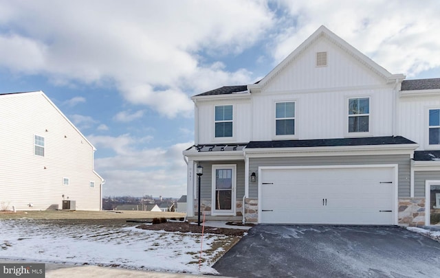 view of front of home featuring a garage and central air condition unit