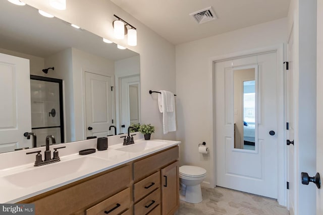 bathroom with toilet, a shower with shower door, and vanity