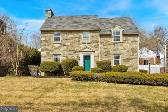 view of front facade with a chimney and a front lawn