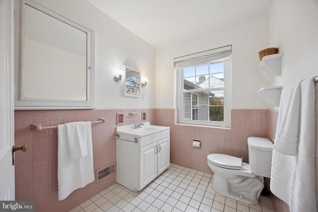 bathroom featuring visible vents, a wainscoted wall, toilet, tile patterned floors, and vanity