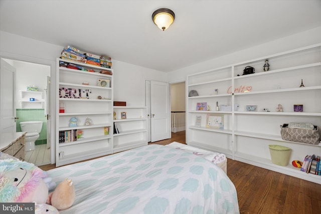 bedroom featuring ensuite bath and wood finished floors