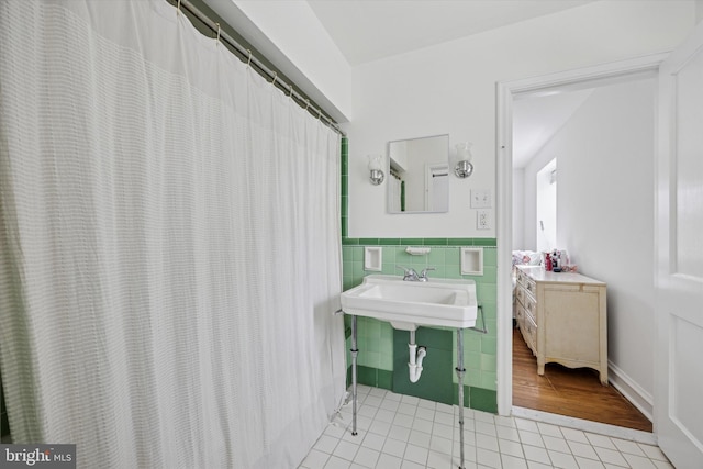 bathroom featuring tile patterned flooring, tile walls, and a wainscoted wall