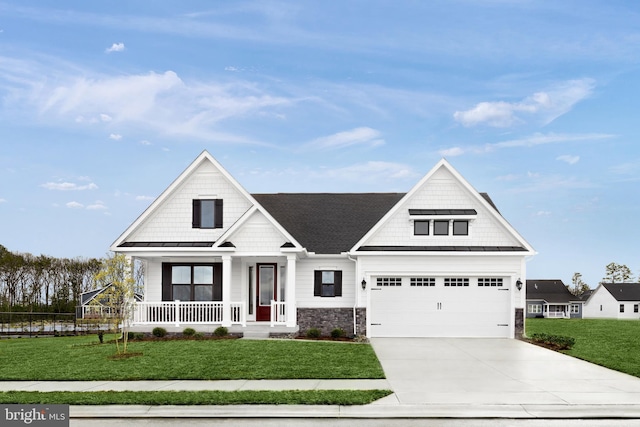 view of front of property with a porch, a front lawn, and a garage