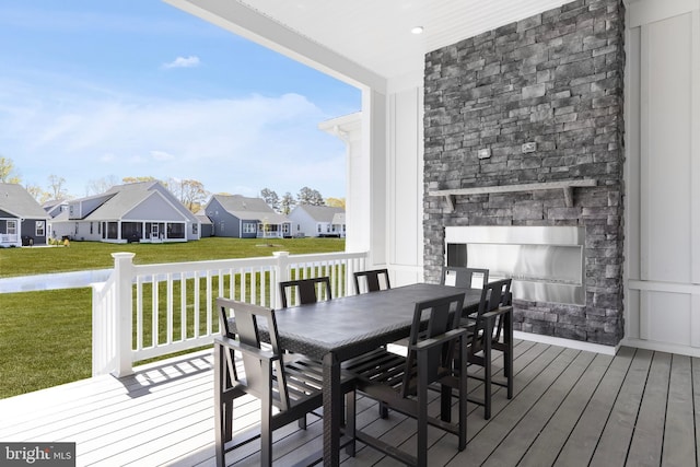 deck featuring a lawn and an outdoor stone fireplace