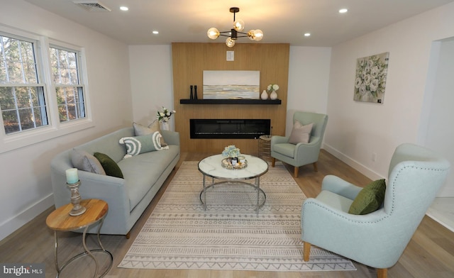 living room with light wood-type flooring and an inviting chandelier