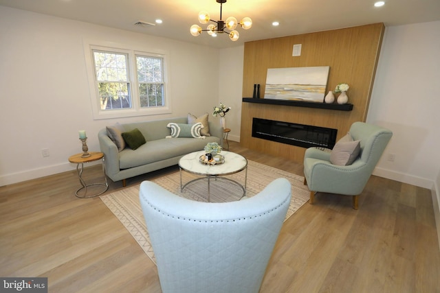 living room featuring light wood-type flooring and a chandelier