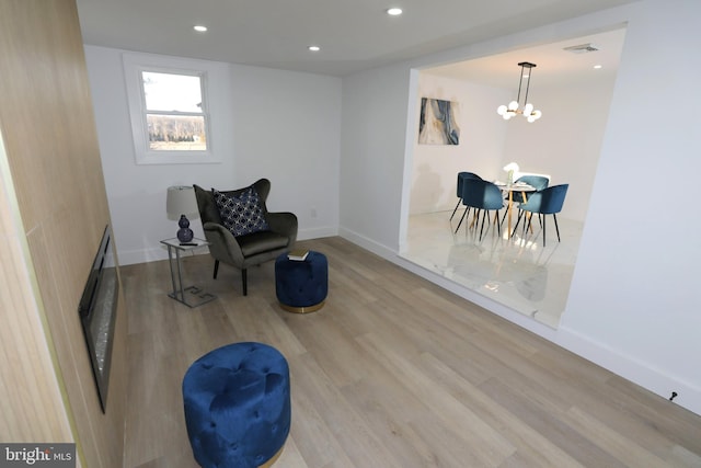 living area with light hardwood / wood-style flooring and a chandelier