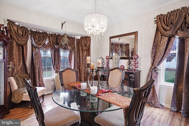 dining area with a healthy amount of sunlight, a chandelier, and light hardwood / wood-style floors