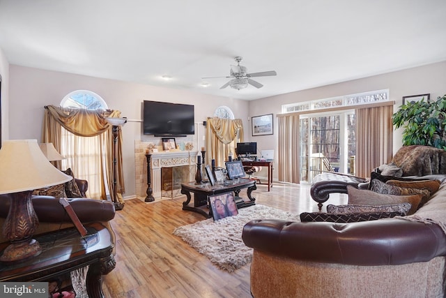 living room featuring ceiling fan, plenty of natural light, and light wood-type flooring