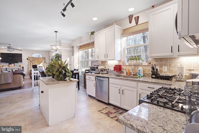 kitchen with dishwasher, a kitchen island, pendant lighting, decorative backsplash, and white cabinets